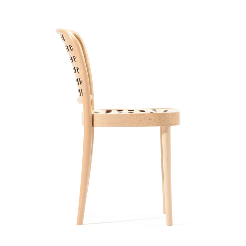Side view of the Chair 822 by TON, a minimalist wooden chair with a curved backrest and seat featuring circular cutouts. Crafted using manual wood-bending technology, this Scandinavian design has four legs and a natural wood finish, embodying modern minimalism.