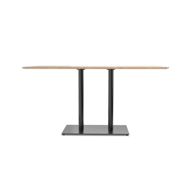 The Easy Bistro Table by TON features a rectangular wooden top with two black metal pillars on a rectangular base, offering minimalist elegance. Ideal for modern interiors, it serves as a stylish choice for bistro and bar settings.