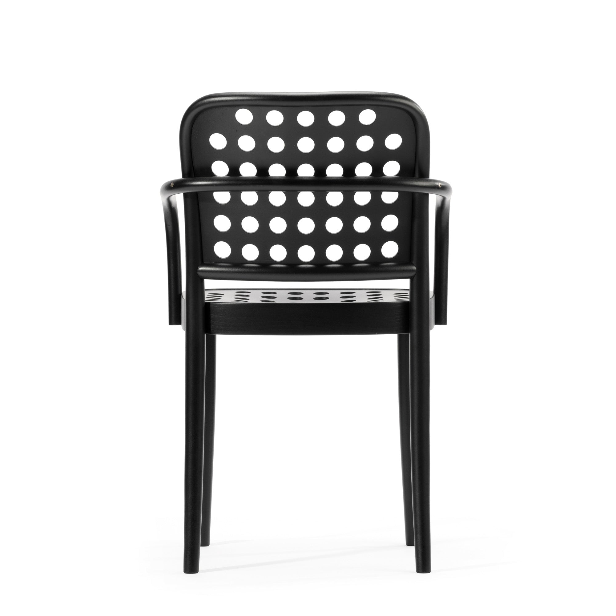 The Armchair 822 from TON epitomizes Scandinavian minimalism with its black design, armrests, and circular perforated backrest. Designed by Claesson Koivisto Rune, it stands against a plain white background as part of the TONDesigner seating collection.