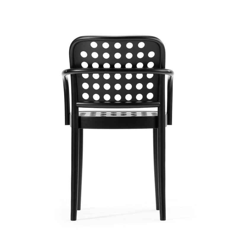 The Armchair 822 from TON epitomizes Scandinavian minimalism with its black design, armrests, and circular perforated backrest. Designed by Claesson Koivisto Rune, it stands against a plain white background as part of the TONDesigner seating collection.