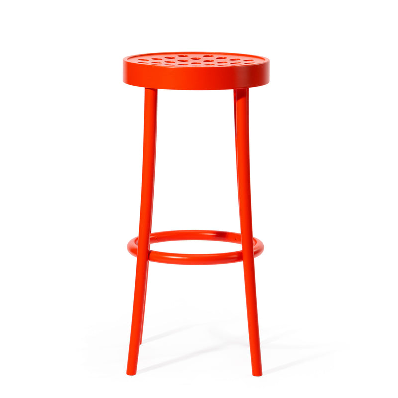 Barstool 822 by TON is a bright orange stool with a round seat featuring a perforated pattern, supported by three slender legs and a circular footrest. Its Scandinavian minimalist design adds a sleek, modern touch to contemporary settings.