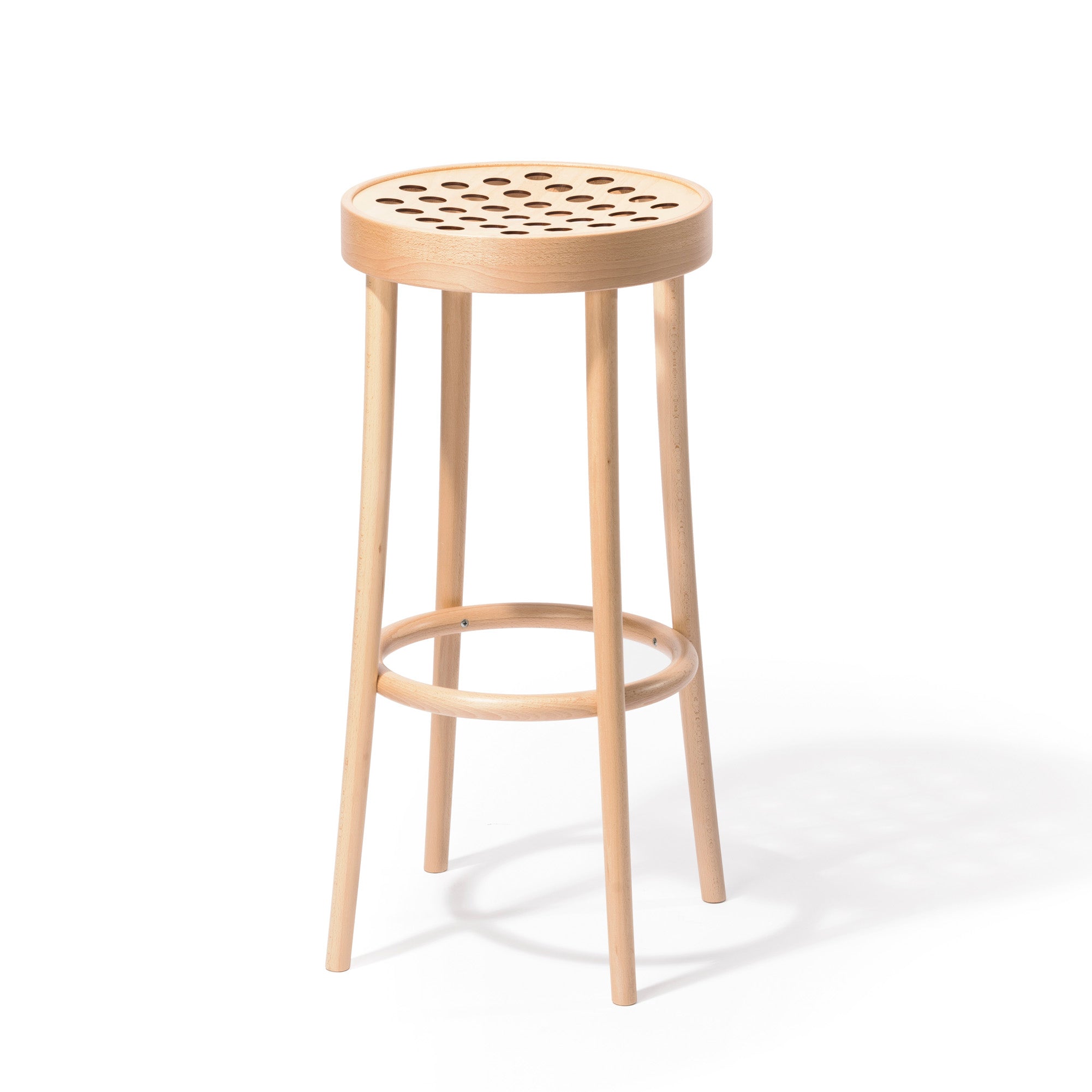 The Barstool 822 by TON exemplifies Scandinavian minimalism with a tall, light wood design featuring a round seat with circular cutouts. It uses manual wood-bending technology and has four slender legs connected by a circular footrest.