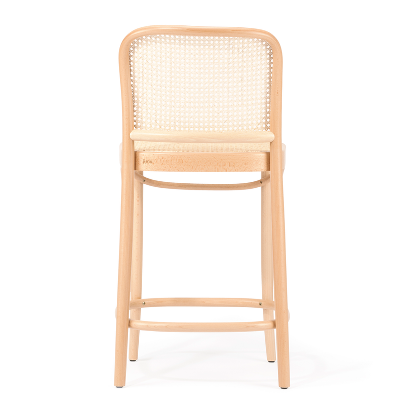 The Barstool 811 - Cane by TON showcases a back view with a rounded cane mesh backrest and light-colored cushioned seat. Crafted from elegant beech wood, its minimalistic design includes long legs and a footrest.