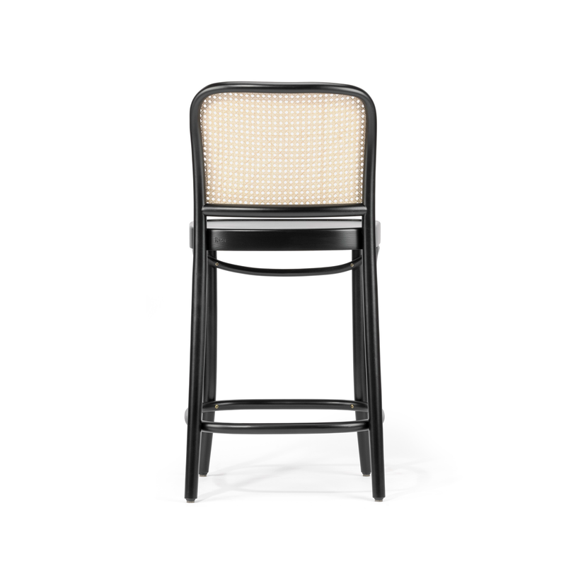 The TON Barstool 811 features a high back crafted from bent beech wood and a woven cane mesh backrest. Its sleek black frame includes a footrest, perfect for enhancing modern or classic interiors. Viewed from the rear, its simple and elegant design stands out.