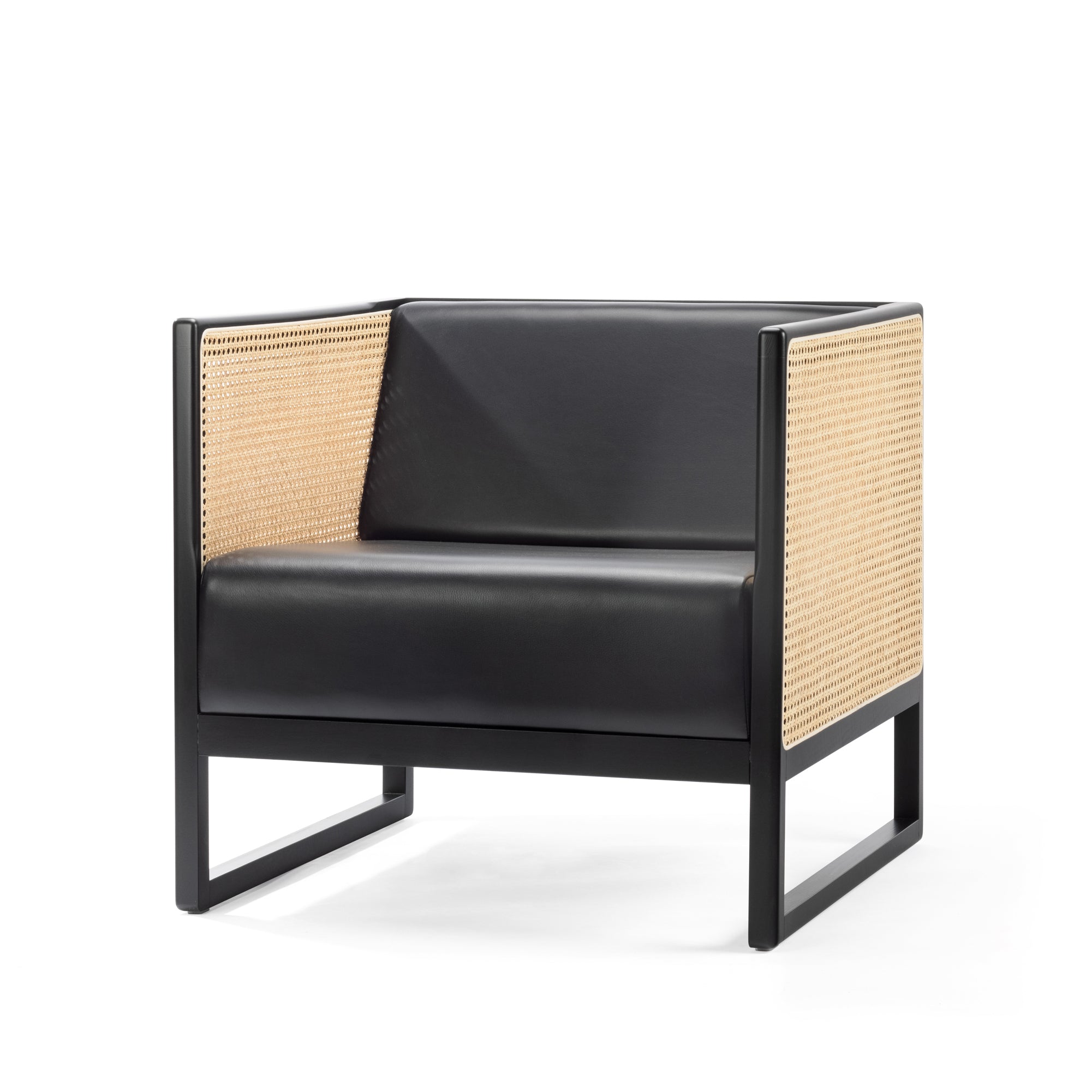 The Armchair Casablanca by TON is a modern black lounge chair featuring a sleek design with cane-weave armrests and a boxy frame, combining leather and natural materials for a minimalist contemporary aesthetic.