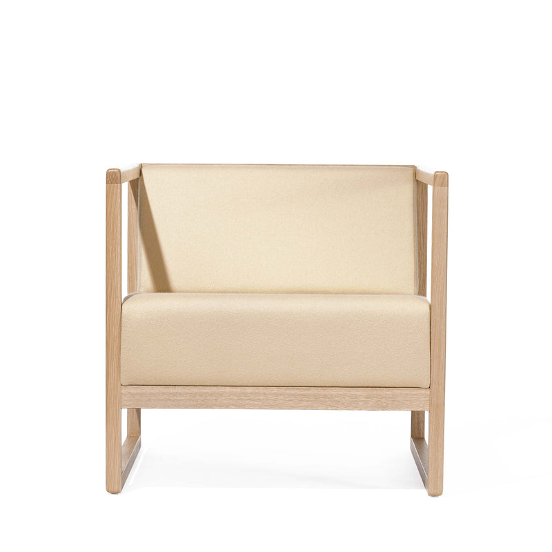 The Armchair Casablanca by TON is a minimalist beige chair with a wooden frame and upholstered seat and backrest, featuring clean lines and open space beneath. Its elegant design is highlighted by cane weave armrests against a plain white background.
