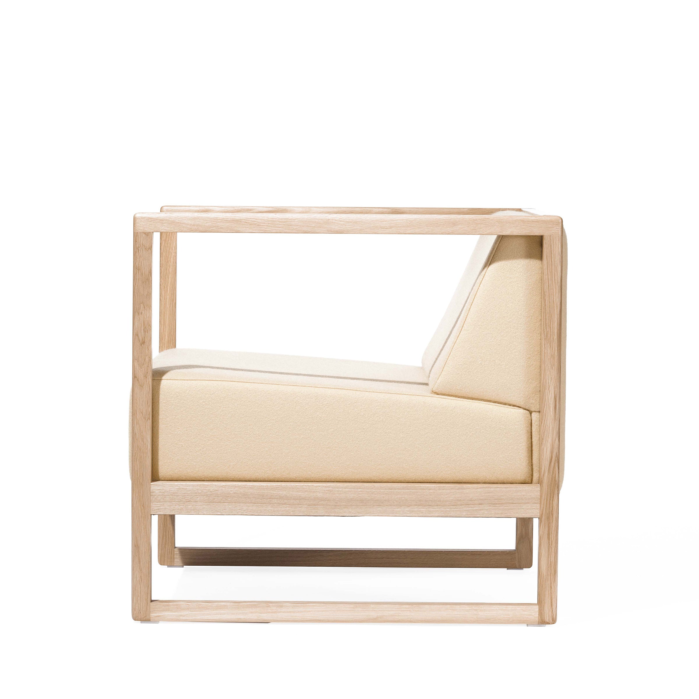 Side view of the Armchair Casablanca by TON, featuring a minimalist design with a light wood frame, cane weave armrests, and beige cushions. Its modern and geometric style highlights clean lines and natural materials.