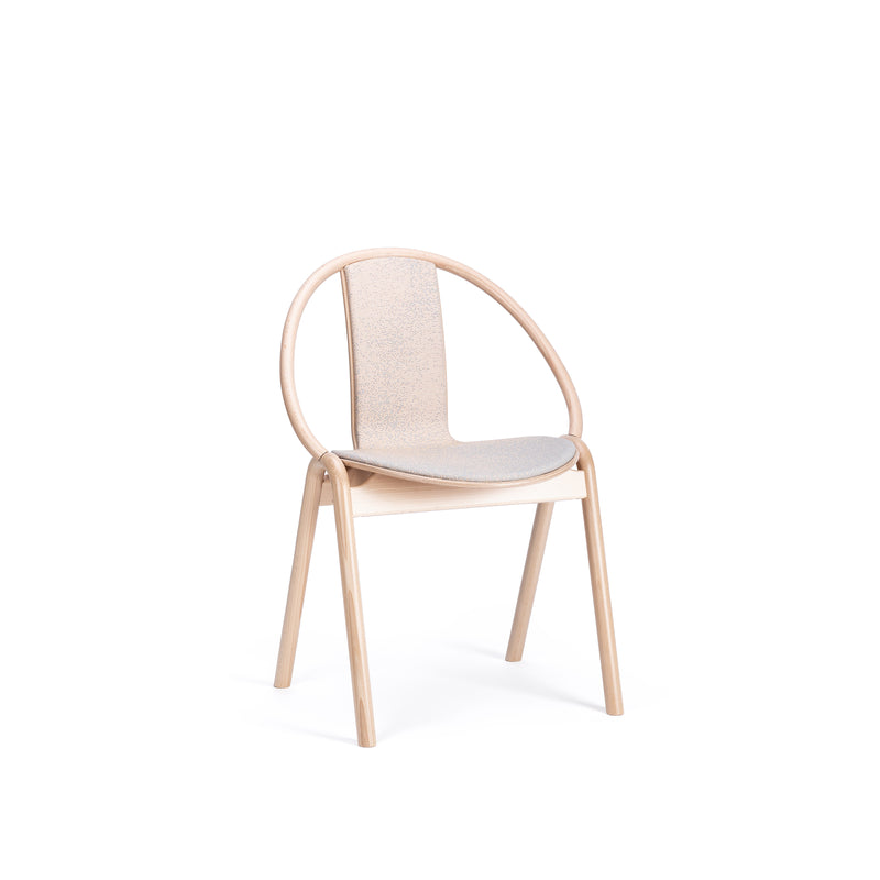 The Chair Again Upholstered by TON features a circular solid beech wood frame and a light fabric seat. The elegant, minimalist design showcases smooth curves on four straight legs, set against a white background for simplicity.