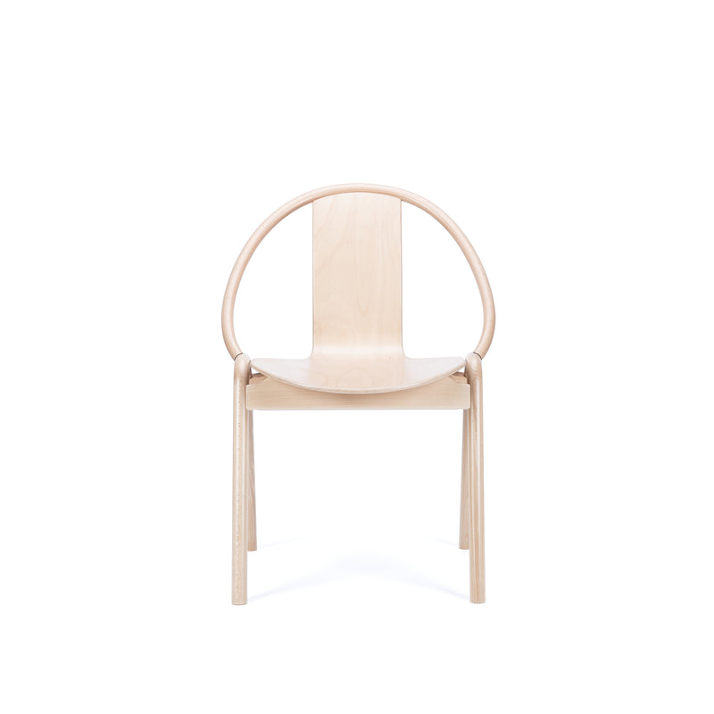 The Chair Again by TON is a minimalist bentwood chair with a circular backrest and flat seat, shown in light color against a white background, showcasing its simple design, smooth finish, and stackable nature for versatile spaces.