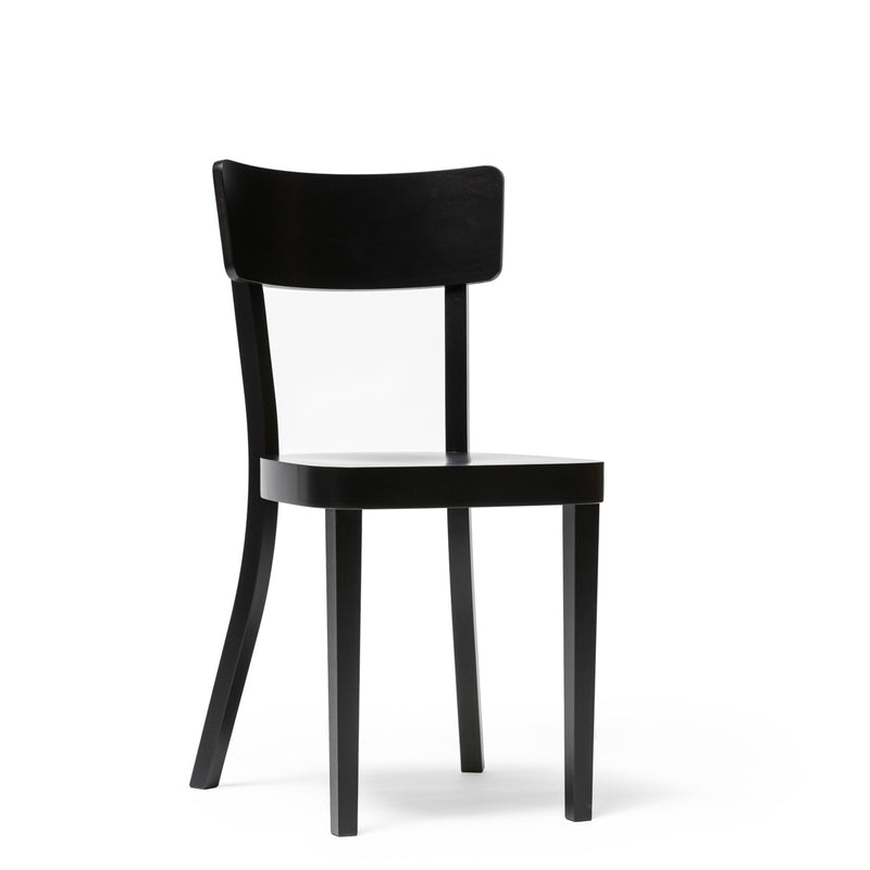The Chair Ideal by TON is a sleek, modern black wooden chair with a curved backrest and four straight legs. It features an upholstered seat, making it perfect for dining. It stands out elegantly against a plain white background.