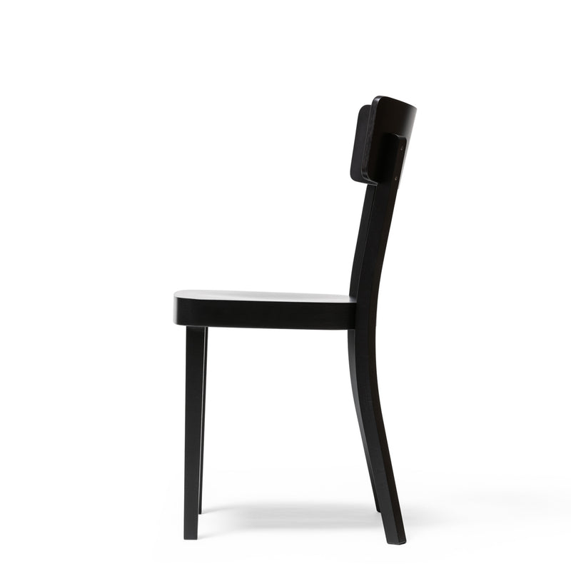 Side view of the Chair Ideal by TON, a modern black dining chair with a minimalist design. It has a flat upholstered seat, slightly curved backrest, beech wood construction, straight legs, clean lines, and is featured against a white background.