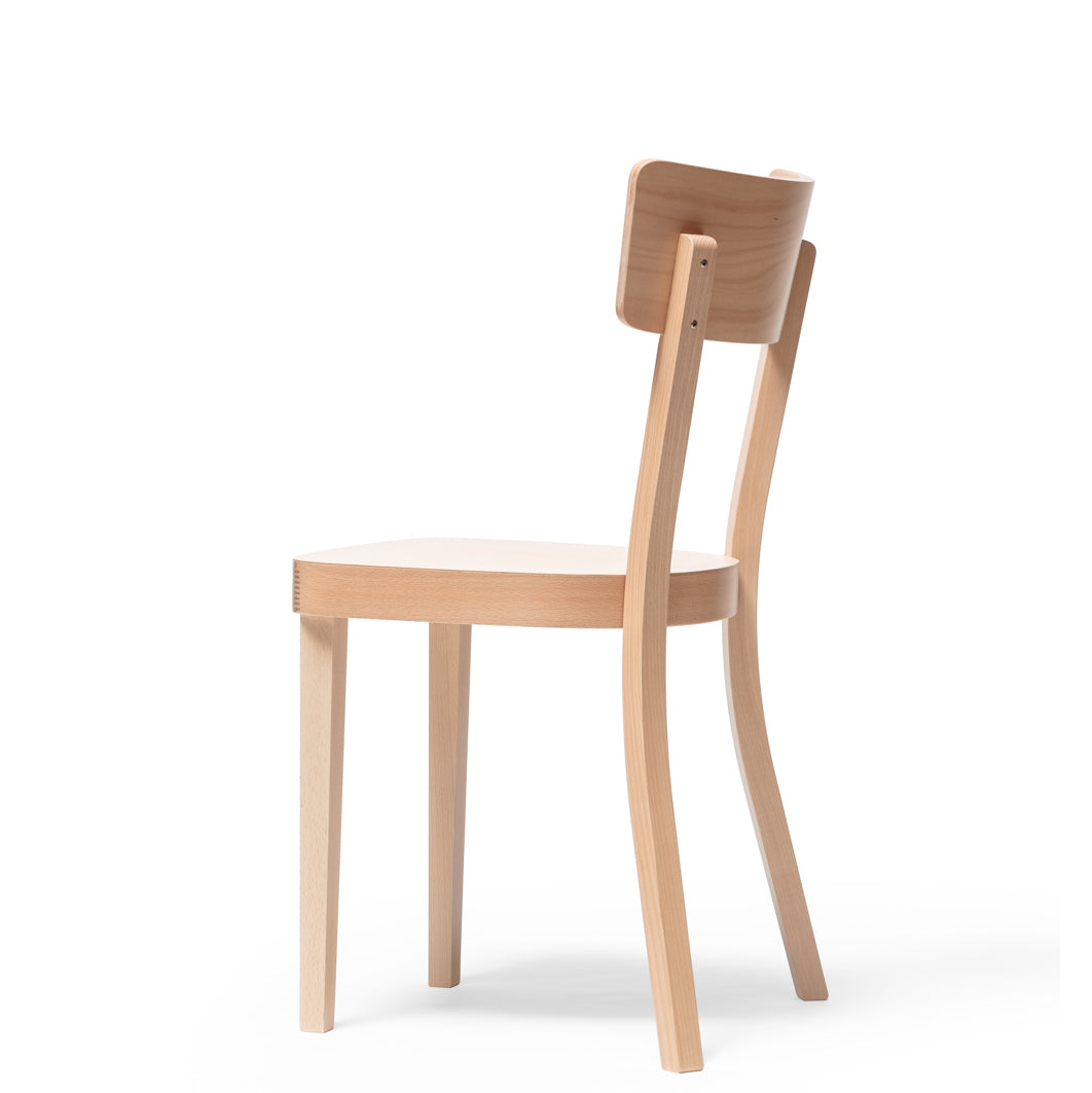The Chair Ideal by TON features a simple design with a slightly curved backrest and upholstered seat. Made from light-colored beech, it stands on four straight legs, perfectly complementing a plain white background.
