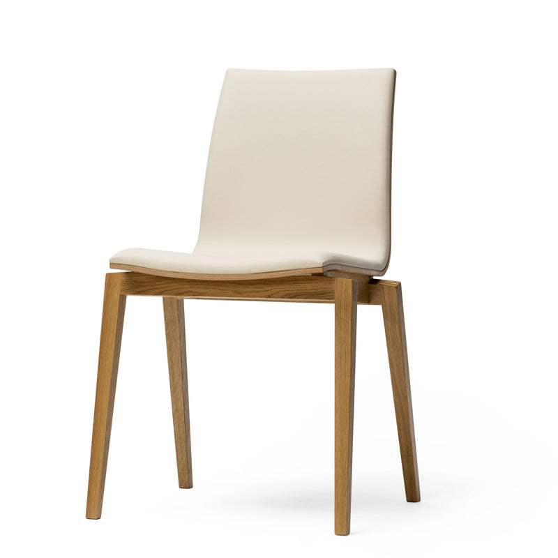 The Chair Stockholm - Upholstered by TON features a white cushioned seat and backrest on a sleek, bent plywood frame with four straight legs, embodying Scandinavian design against a plain white background.