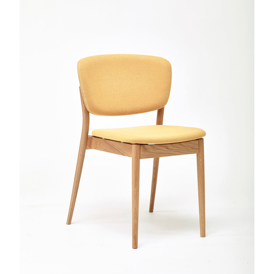 The Chair Valencia Upholstered - Sale by TON is a minimalist wooden chair, featuring an ergonomic design with a yellow cushioned seat and backrest, angled slightly to showcase its elegant shape against a plain white background.