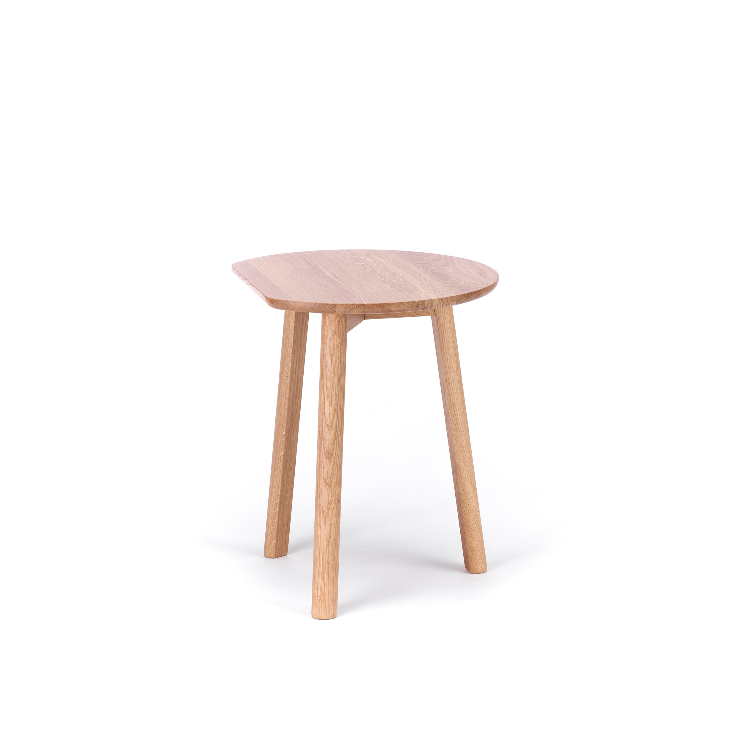 The YYY Coffee Table by TON is a small, round table crafted from natural oak, showcasing a minimalist design with a polished surface and tapered legs. This elegant piece, perfect for refined spaces, stands gracefully against a plain white background.