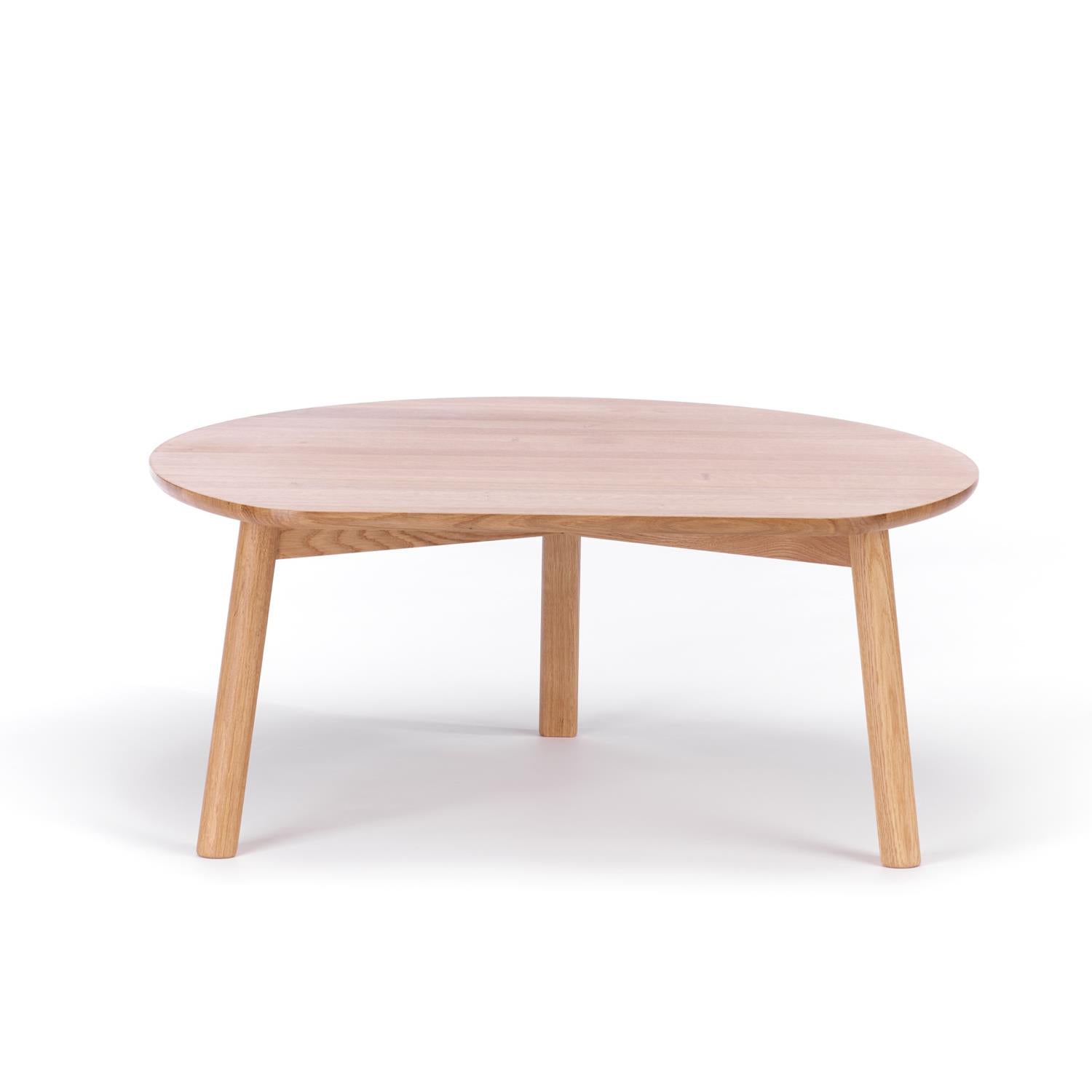 The YYY Coffee Table by TON is a round wooden piece crafted from natural oak, featuring a smooth, light surface and three angled legs for a minimalist, modern design. Set against a white background, it highlights the beauty of natural materials in coffee tables.