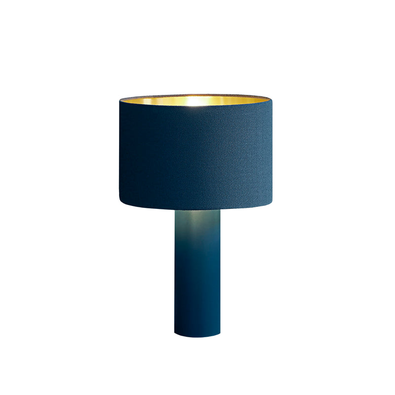 The ALL ROUND Table Lamp by Victor Foxtrot features a powder-coated steel base and a dark blue round wool fabric shade with an inner gold lining for a warm glow, complementing its sleek minimalist design.