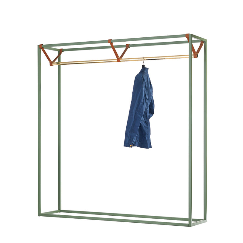 The Victor Foxtrot LESS MESS Coat Stand is a minimalist, freestanding clothes rack made of powder-coated steel with a light green frame and polished brass horizontal bar. It supports a blue jacket with triangular brackets for stability.