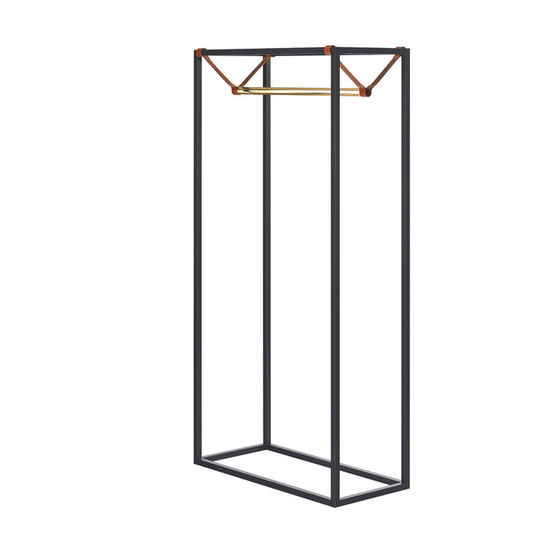 The LESS MESS Coat Stand by Victor Foxtrot is a minimalist metal clothing rack featuring a powder-coated steel rectangular frame in black, a polished brass hanging rod, and vegetable tanned leather corner straps, offering a sleek and modern design perfect for displaying clothes.