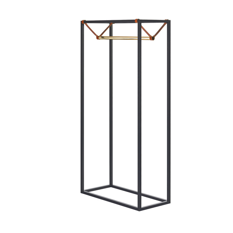 The LESS MESS Coat Stand by Victor Foxtrot is a minimalist metal clothing rack featuring a powder-coated steel rectangular frame in black, a polished brass hanging rod, and vegetable tanned leather corner straps, offering a sleek and modern design perfect for displaying clothes.