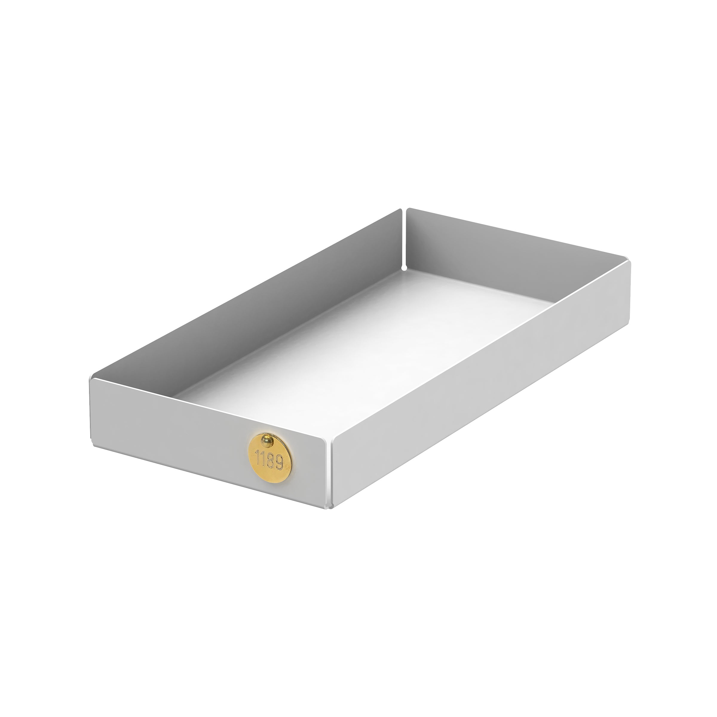 The POI Tray M by Victor Foxtrot is a rectangular, silver tray made from powder-coated steel with raised edges. It features a small round gold tag on one corner displaying the number 1189, and it sits empty and isolated against a white background, perfect for design lovers.