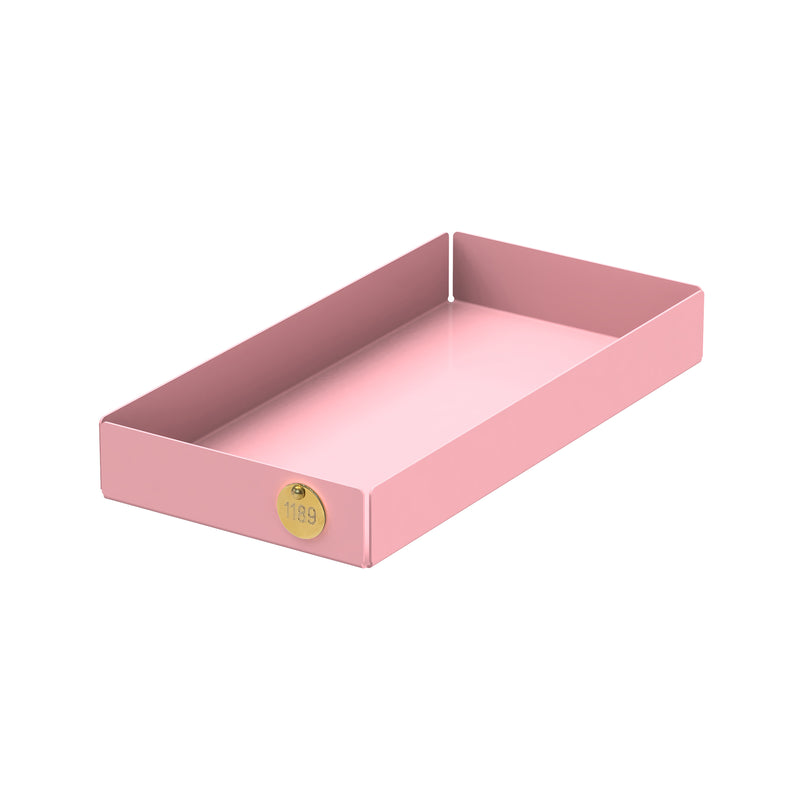 The POI Tray M by Victor Foxtrot is a rectangular pink tray made of powder-coated steel. It features a high rim and a small round golden label with 1189, making it ideal for design enthusiasts. Set on a white background, this tray adds elegance to any space.