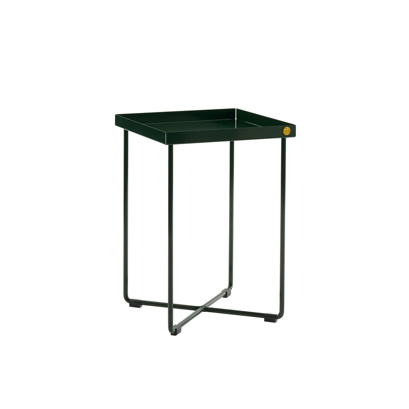 The POI MINI Side Table by Victor Foxtrot is a small square green metal bedside table with slim legs crossing at the base and a raised edge top, highlighted by a minimalist circular gold emblem on one corner.