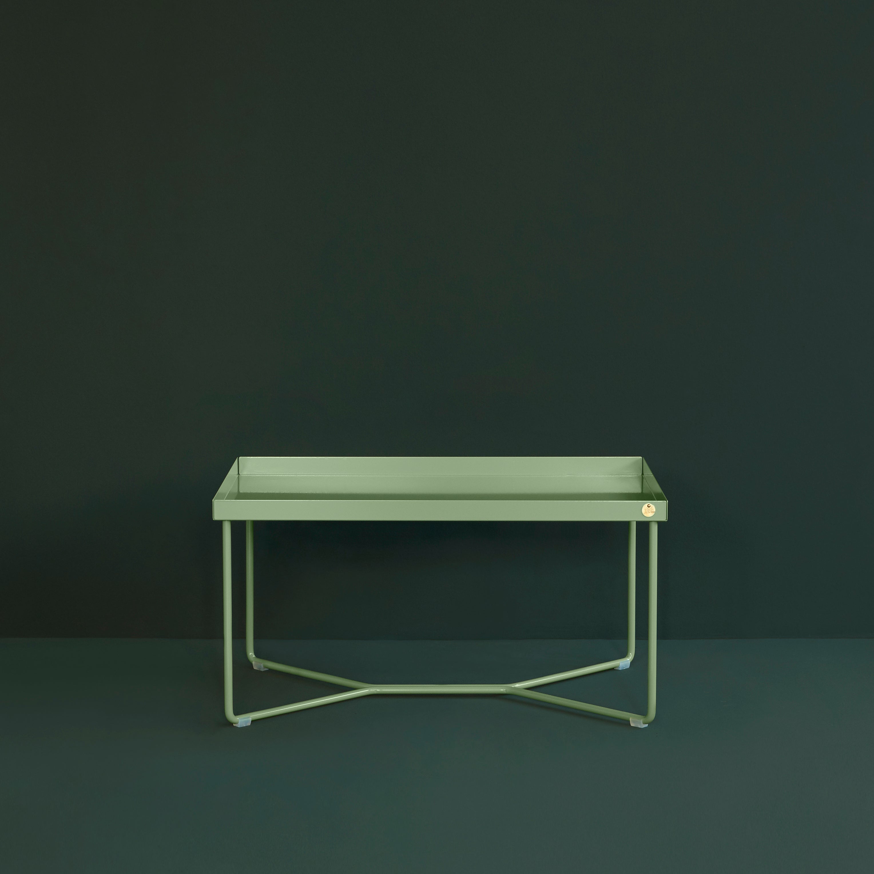 The POI SINGLE Side Table by Victor Foxtrot is a minimalist rectangular design with thin powder-coated steel legs set against a dark green background, showcasing clean lines and uniform color.