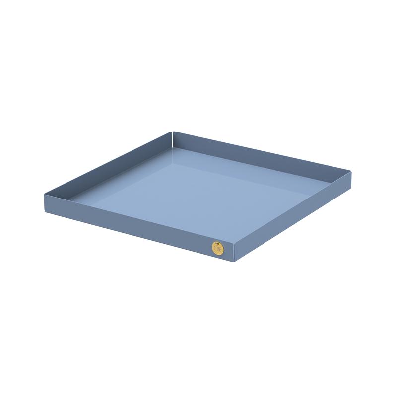 The POI Tray XL by Victor Foxtrot is a square, light blue metal tray made from powder-coated steel. It features a small round gold sticker on the front edge and subtly raised edges, appealing to design lovers against a pristine white background.
