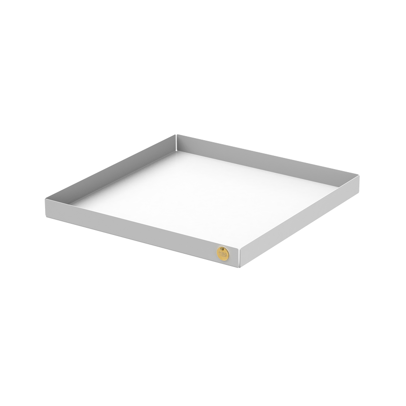 The Victor Foxtrot POI Tray XL is a square, shallow tray made from powder-coated steel. It has a gray exterior and white base, with a small round golden emblem in one corner. Set against a plain white background, this elegant piece is ideal for design enthusiasts.