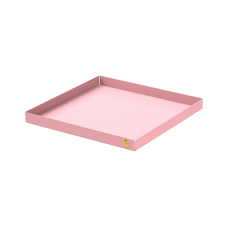 The POI Tray XL by Victor Foxtrot is a pink, square, shallow tray crafted from powder-coated steel with raised edges and a gold emblem. Its sleek, minimalistic design and soft, glossy finish make it perfect for design lovers seeking elegance.