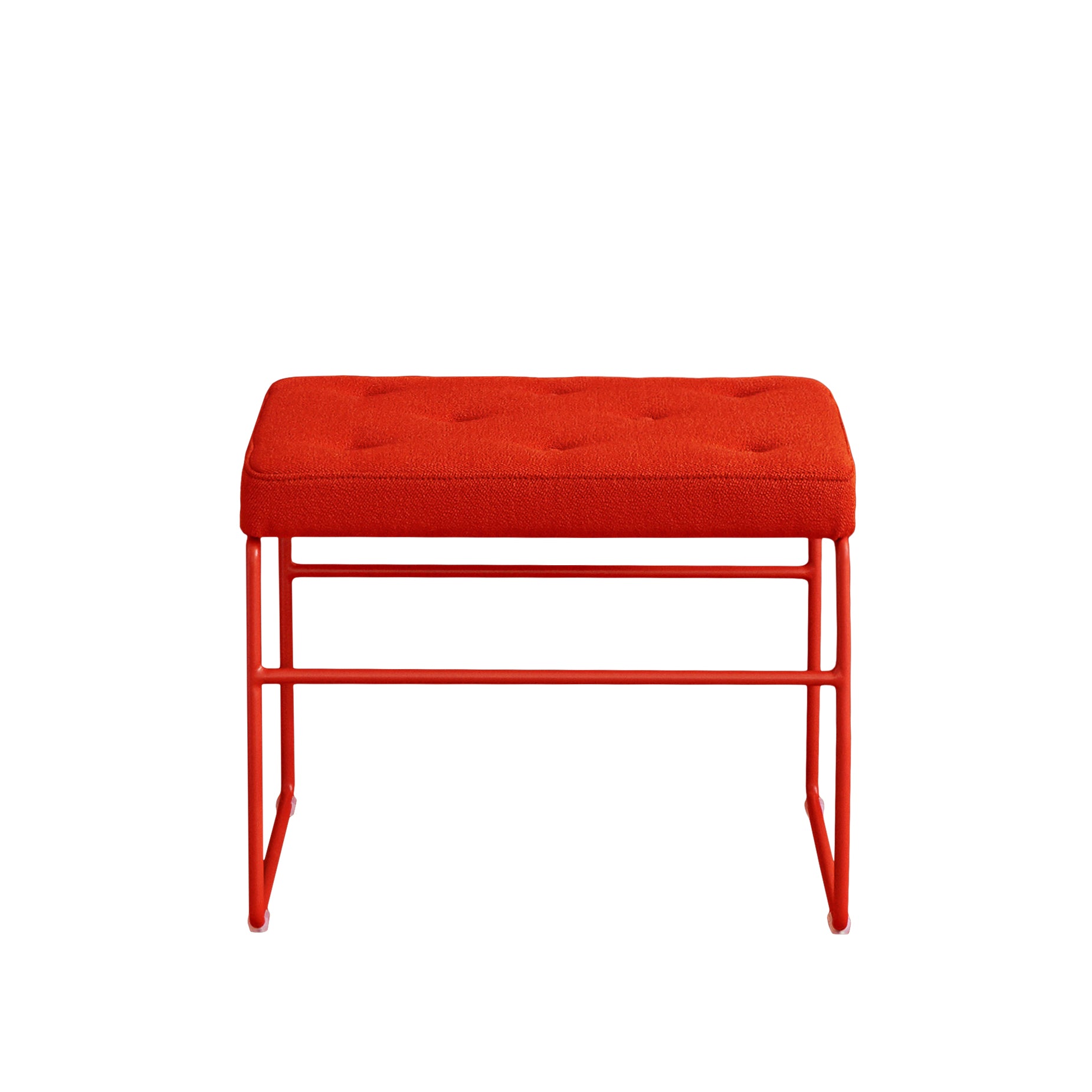 The SWELL TIME Ottoman from Victor Foxtrot, featuring a bright red cushioned button-stitched seat and slender steel legs, captures the charm of British upholstered furniture and is elegantly displayed from the front against a white background.