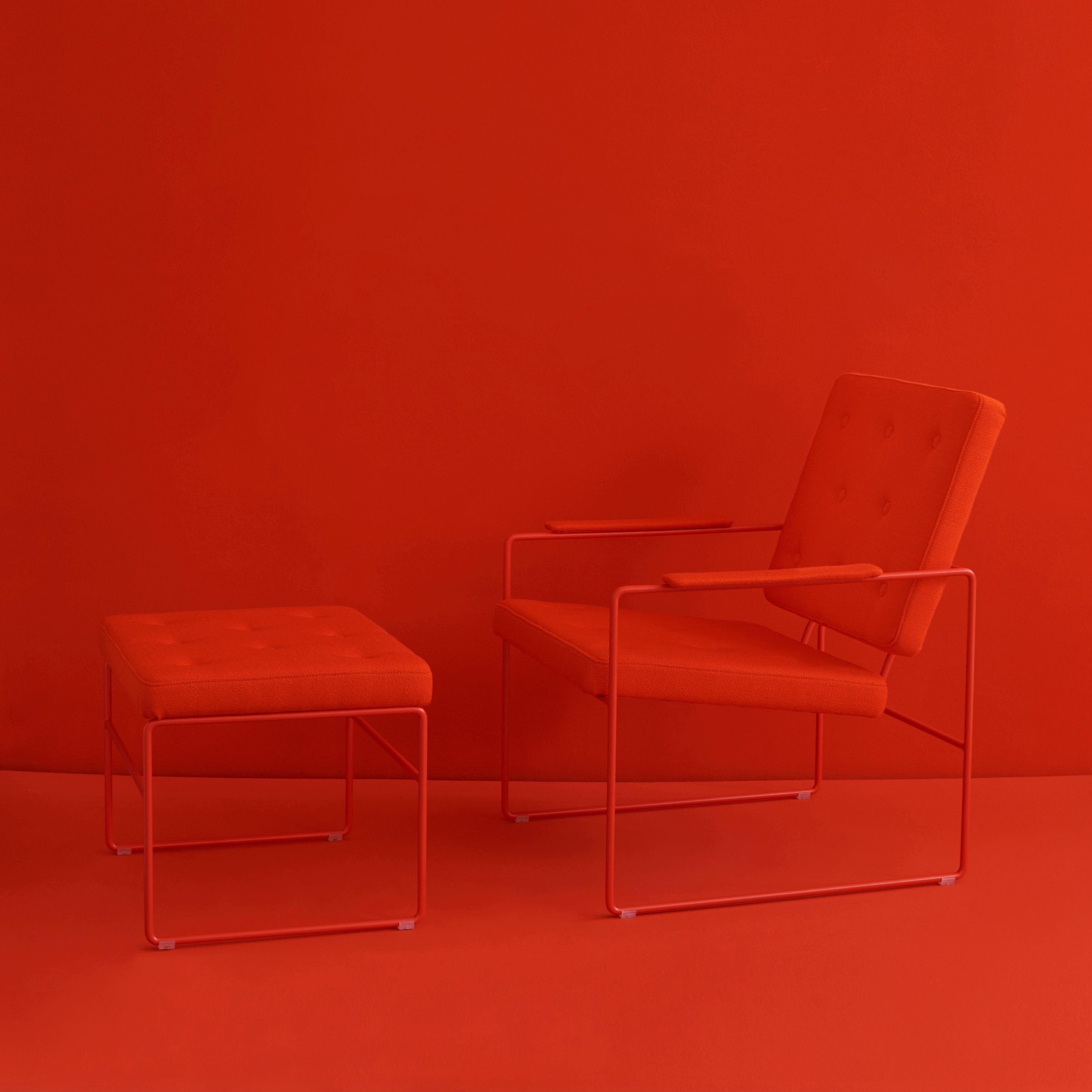 The SWELL TIME Lounge Chair by Victor Foxtrot, featuring British upholstery and tufted cushions, comes with metal legs and a matching ottoman against an orange background. This modern designer set is perfect for minimalist decor.