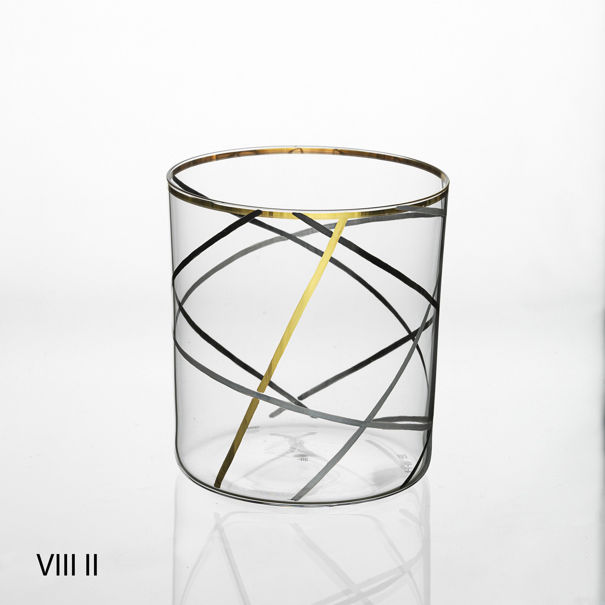 The Neo Light VIII Enamel Collection by Lobmeyr features a transparent glass with elegant gold and black crisscrossing lines, a gold rim, and Roman numerals VIII II in the bottom left. Designed by Martino Gamper, its a contemporary ornament against a plain white background.