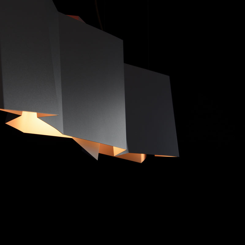 The ZIG ZAG Pendant Lamp by Victor Foxtrot features geometric, angular shades suspended against a dark background, casting a warm glow. Perfect for restaurant lighting, its minimalist design emphasizes sharp lines and contrasts to enhance any bar counter illumination.