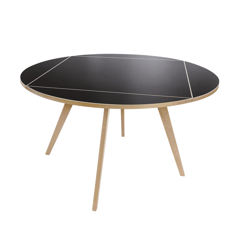 The Quadrat-Rund Table by WB Form is a black round table with minimalist style, featuring light wooden tripod legs and fine white geometric lines, echoing the refined Wohnbedarf Zurich aesthetic.