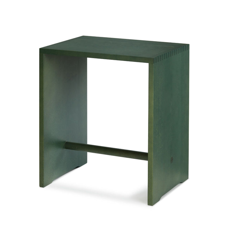 The WB Form Ulmer Stool, inspired by Max Bills design, is a green wooden side table with a rectangular shape and open sides. A horizontal support bar connects the panels, offering a minimalist and modern look against a plain white background.