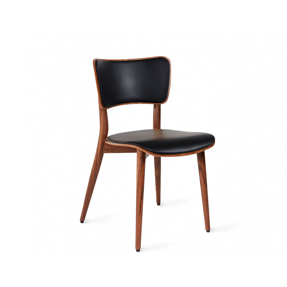 The Kreuzzargenstuhl Upholstered chair by WB Form features a wooden frame with four tapered legs, a black leather seat and backrest bordered by wood, and offers versatile upholstery options to match any decor with its sleek, minimalist design set against a white background.
