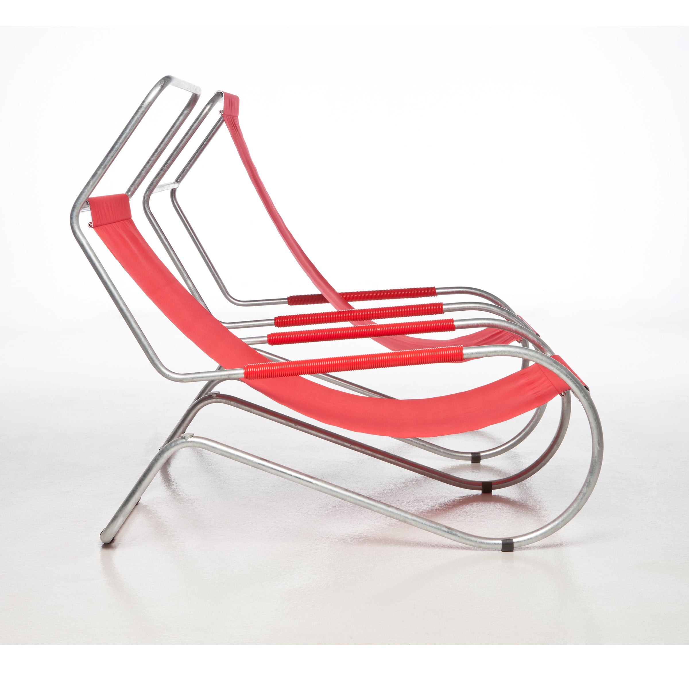 Three Lido Lounger chairs by WB Form, with red fabric seats and sleek silver metal frames, are aligned on a white surface. These tubular steel loungers have a curved design that emphasizes a minimalist aesthetic.