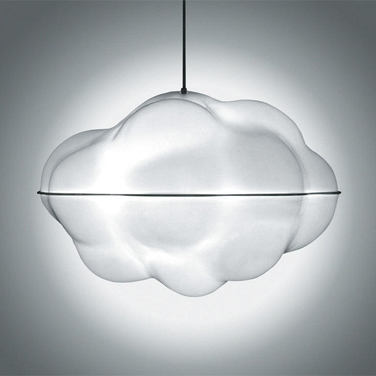 The WB Form Cloud Lamp, with its smooth white exterior and delicate design, is suspended against a neutral background. It emits a soft glow that enhances its fluffy, cloud-like resemblance to a meticulously crafted polystyrene sculpture.