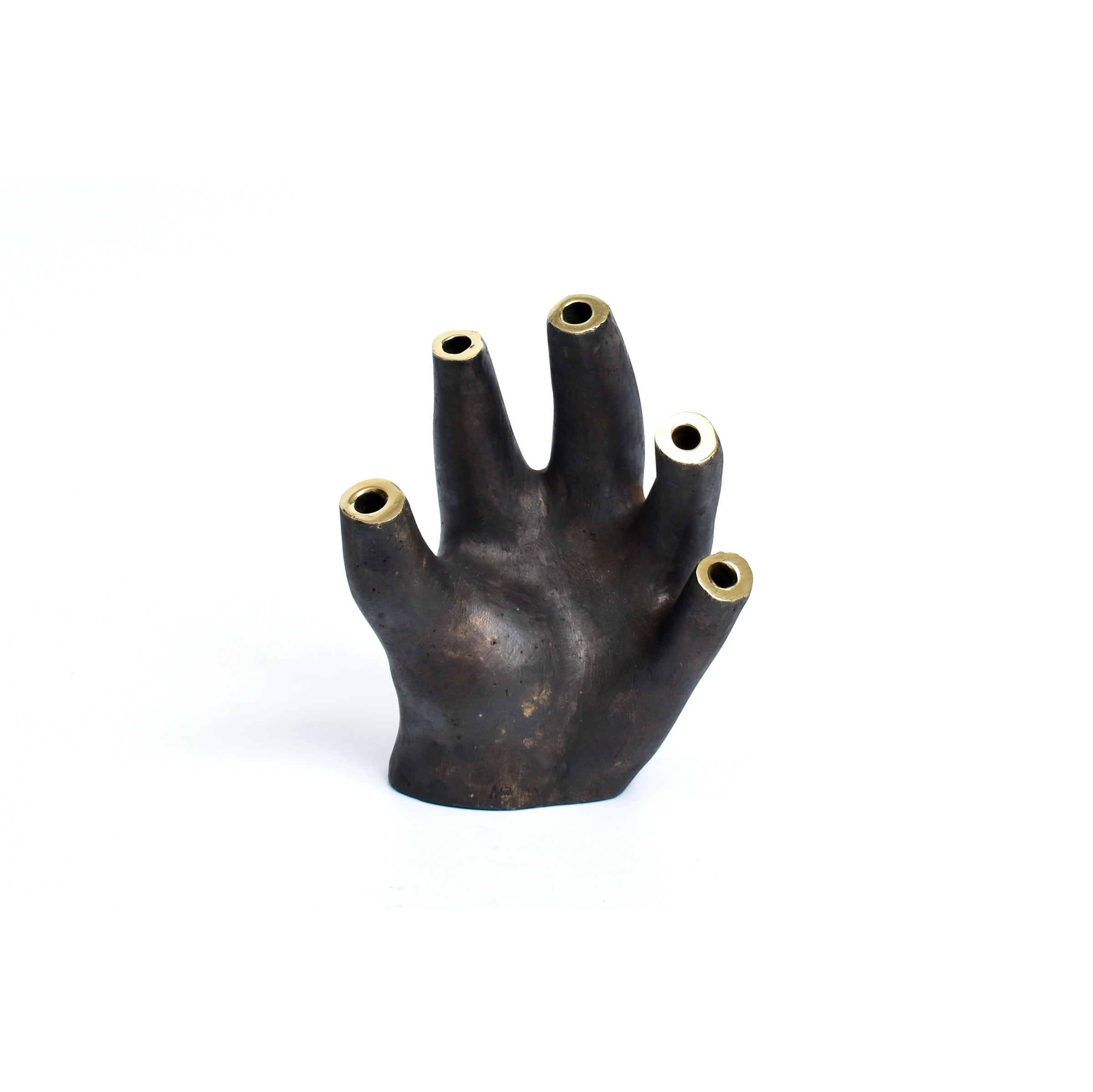 Vase Glove #3788 by Werkstätte Carl Auböck is a dark, sculptural piece resembling an abstract hand with five cylindrical openings. Its textured surface and artistic flair are reminiscent of designs showcased at the Triennale di Milano.