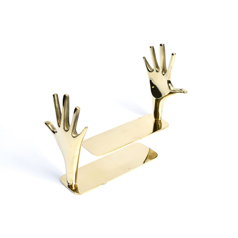The Pair of Bookends Jazz Hands #4219 by Werkstätte Carl Auböck features a modern, artistic flair with gold-colored hands on rectangular bases, echoing the elegance of a Viennese townhouse. They evoke Carl Auböcks style while supporting books and adding a decorative touch to any space.