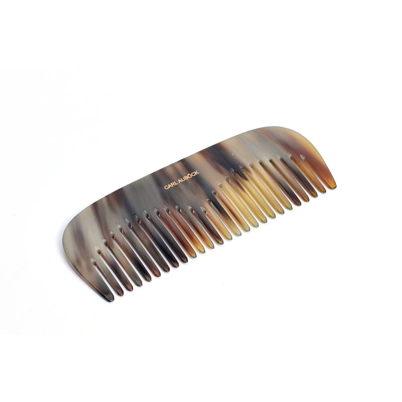 The Horn Comb Ladies #7084 by Werkstätte Carl Auböck showcases a tortoiseshell pattern with blended brown and beige shades. Its smooth, curved edge and evenly spaced wide teeth are perfect for gentle hair detangling.