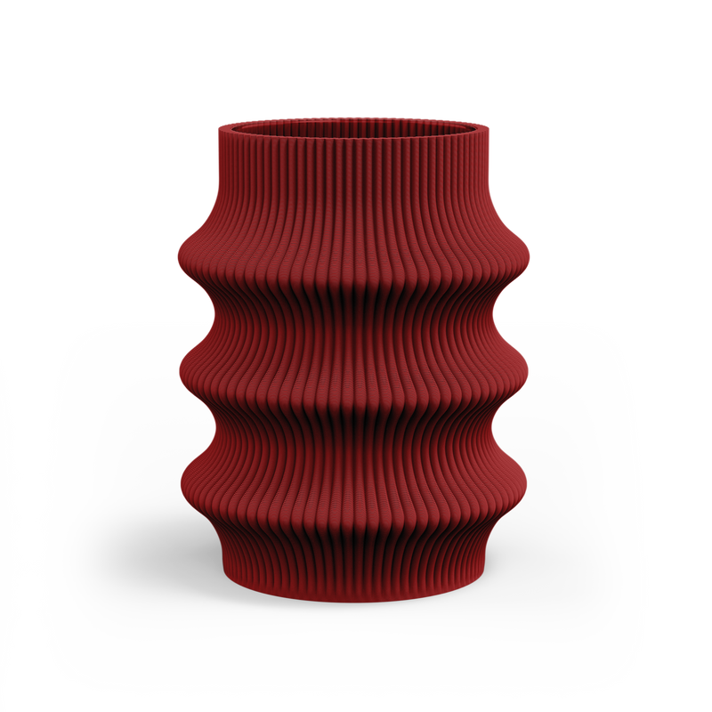 The Zayl 129g Vase by Sheyn is a red, cylindrical piece with a ribbed, wavy surface, created through eco-friendly 3D printing. Its undulating design on a white background highlights modern digital innovation and sustainability.