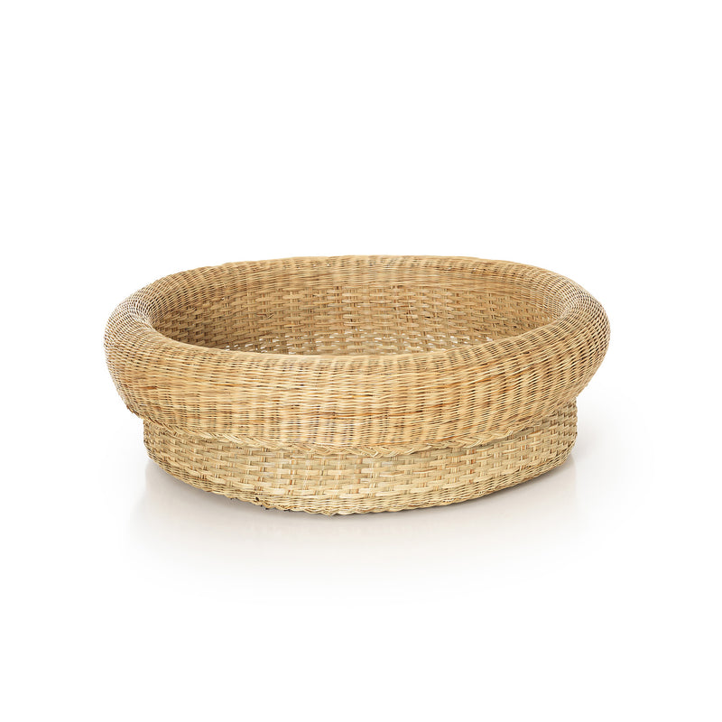 The Ames Fibra Basket Large by Ames is a handcrafted, round, shallow wicker basket made in Colombia from esparto grass, featuring a thick rolled rim and shown on a white background.