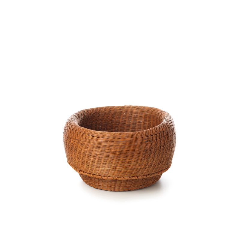 The Ames Fibra Basket by Ames is a round, empty wicker basket handcrafted in Colombia from esparto grass, featuring a wide opening and sturdy base, shown against a plain white background.