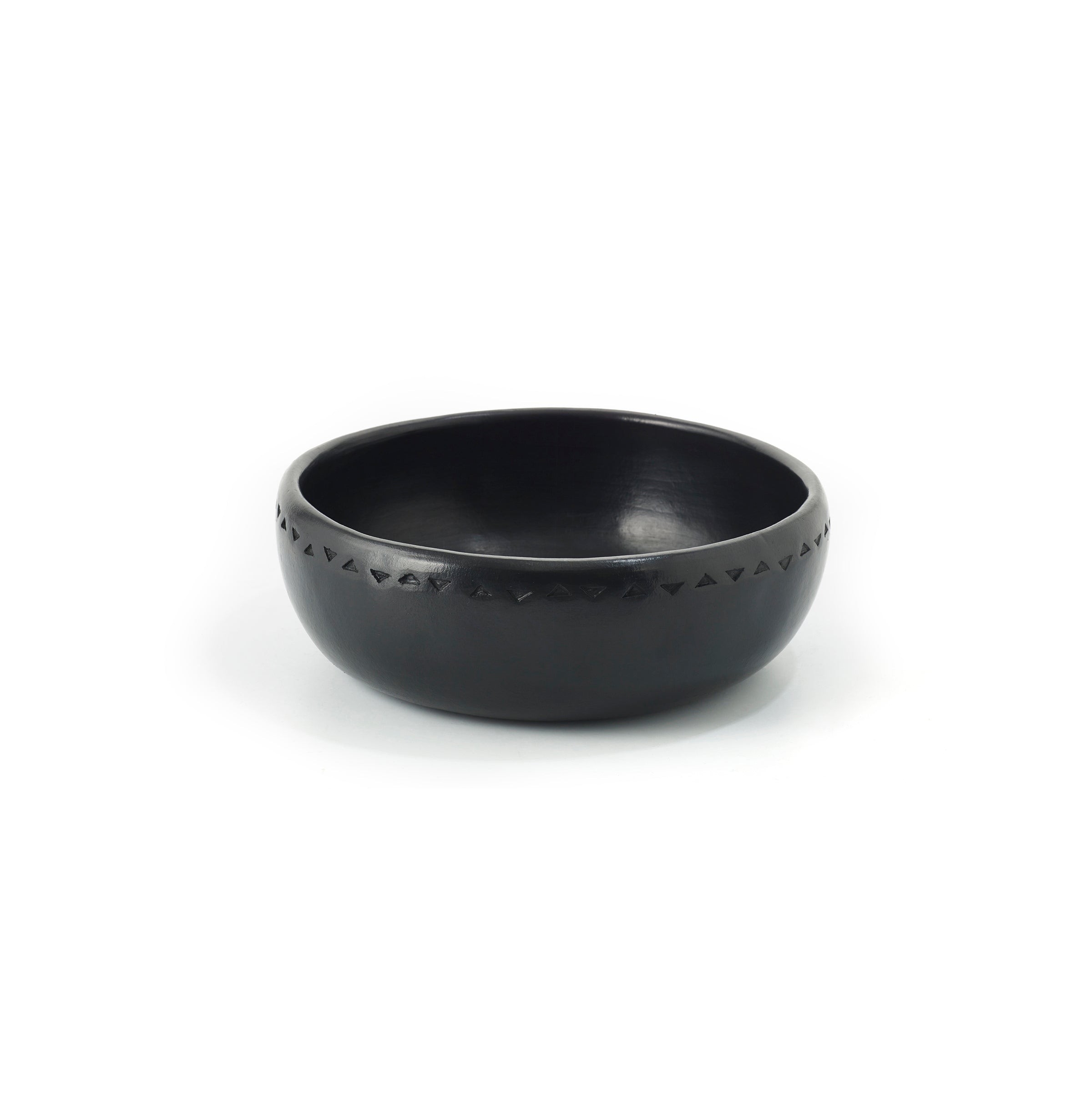 The Barro Bowl by Ames is a black ceramic bowl showcasing traditional pottery with a simple geometric pattern around the rim, set against a plain white background.