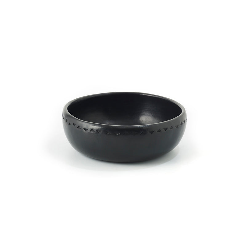 The Barro Bowl by Ames is a black ceramic bowl showcasing traditional pottery with a simple geometric pattern around the rim, set against a plain white background.