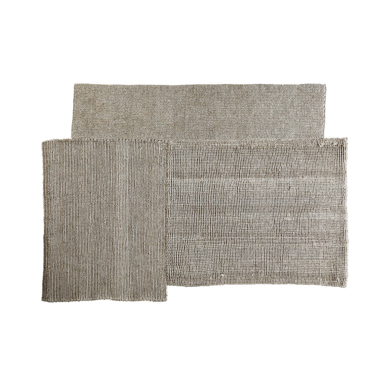 The Cabuya Rug by Ames is a modern rectangular design made from flame-retardant fibers in monochromatic tan. Its textured pattern of overlapping sections stands out against a white background, making the Sebastian Herkner piece an eye-catching focal point.