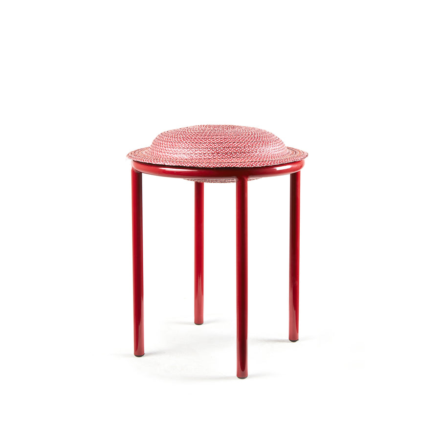 The Ames Cana Stool has a textured, circular seat on three round legs. Its vibrant colors contrast with a plain white background, adding style to any modern space.